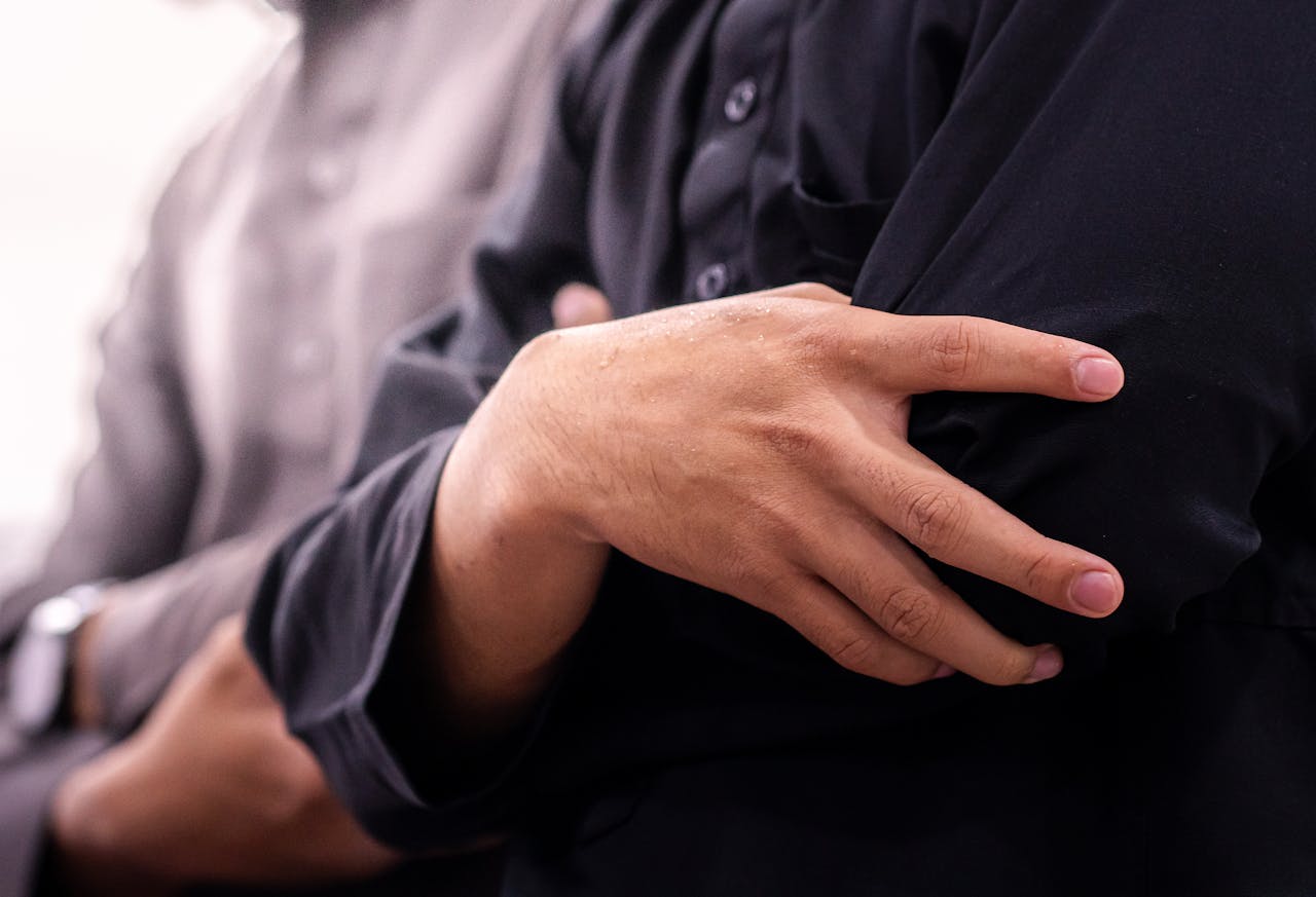 Home Focused image showing hands clasped in prayer during a religious gathering in an Indonesian mosque.