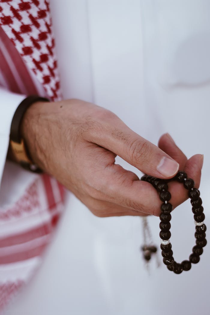 Services A man holding Islamic prayer beads, emphasizing devotion and spirituality.
